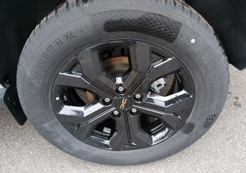 Gros plan sur la roue noire brillante du Dacia Duster Hybrid-G 150 ch, pneu Continental 225/60 R17, détail du jante moderne.