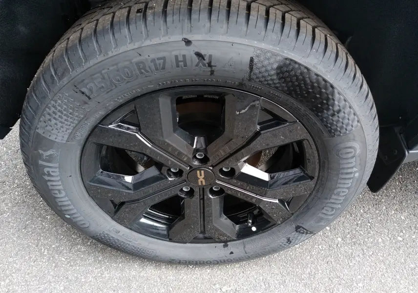 Gros plan sur la roue avant droite du Dacia Duster Hybrid-G 150 ch, jante noire brillante avec pneu Continental.