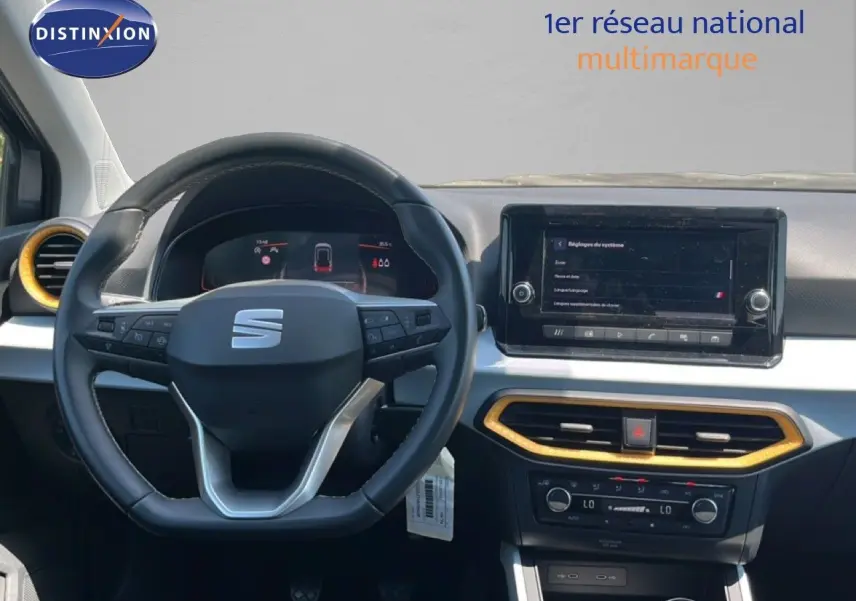 Vue intérieure frontale du poste de conduite du SEAT Arona gris Magnetic Metal avec volant cuir noir et écran tactile central.