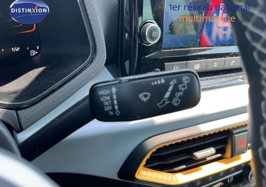 Gros plan intérieur sur la commande d’essuie-glace du SEAT Arona 2025, avec tableau de bord et écran tactile visibles.