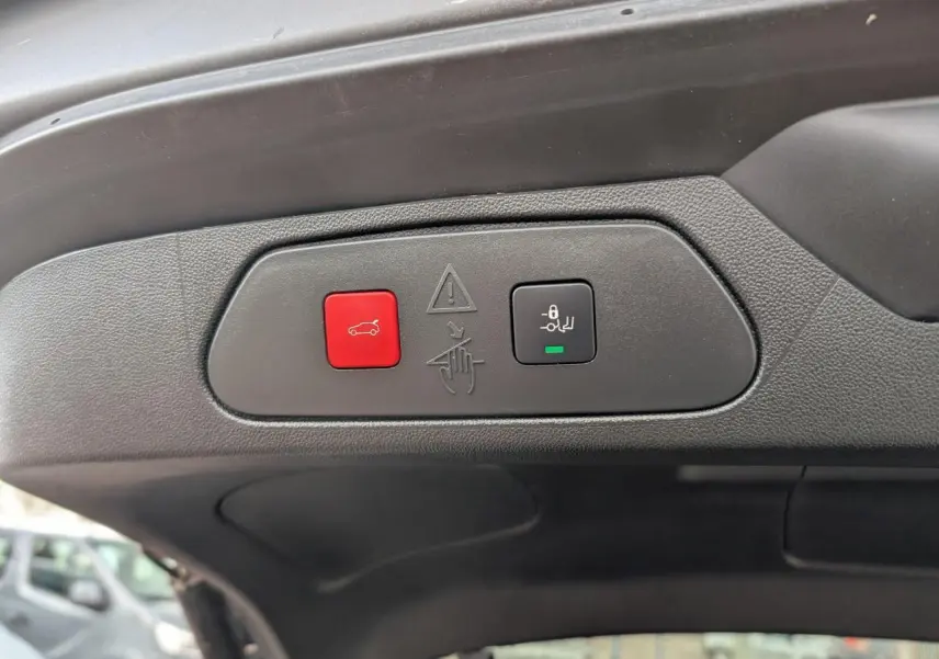 Gros plan sur les boutons de hayon motorisé avec ouverture mains-libres du coffre du Opel Grandland blanc métallisé.