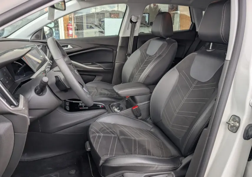 Vue intérieure côté conducteur de l’Opel Grandland blanc, sièges en Alcantara noir avec surpiqûres contrastées.