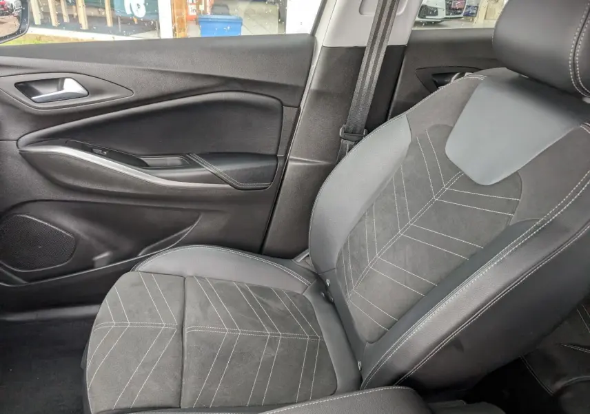 Vue intérieure côté passager avant de la sellerie Alcantara/TEP noire avec surpiqûres blanches de l'Opel Grandland 2024.