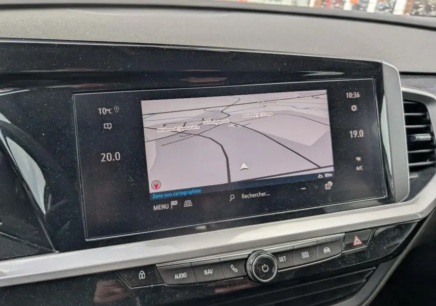 Vue intérieure centrée sur l'écran tactile du système de navigation du tableau de bord de l'Opel Grandland blanc.