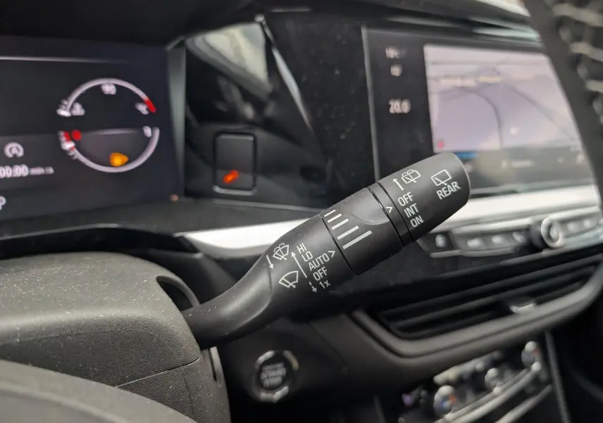 Gros plan sur la commande des essuie-glaces à gauche du volant dans l’habitacle d’un Opel Grandland blanc 2024.