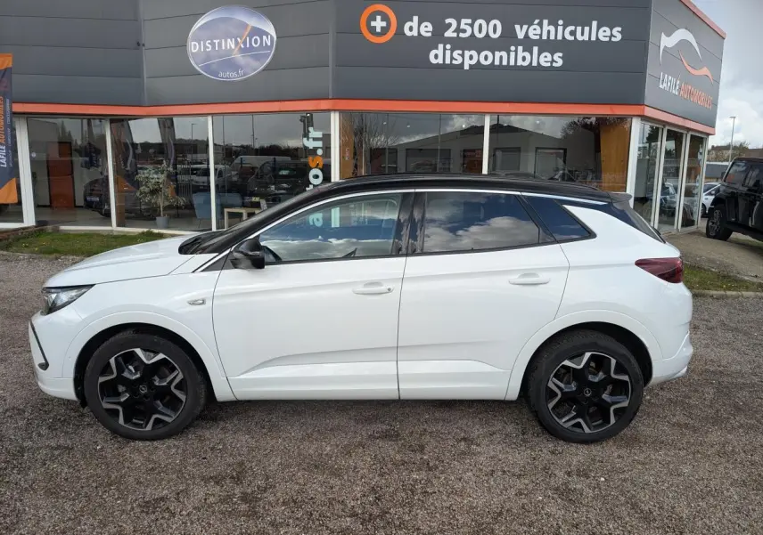 Opel Grandland 2024 blanc métallisé en profil droit, toit noir brillant et jantes alliage noires distinctives.