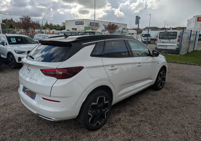 Opel Grandland blanc métallisé vue 3/4 arrière droit avec toit noir et jantes alliage noires 19 pouces.