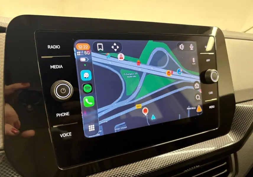 Écran tactile central du Volkswagen T-Cross 2024 affichant la navigation avec interface connectée et commandes autour.