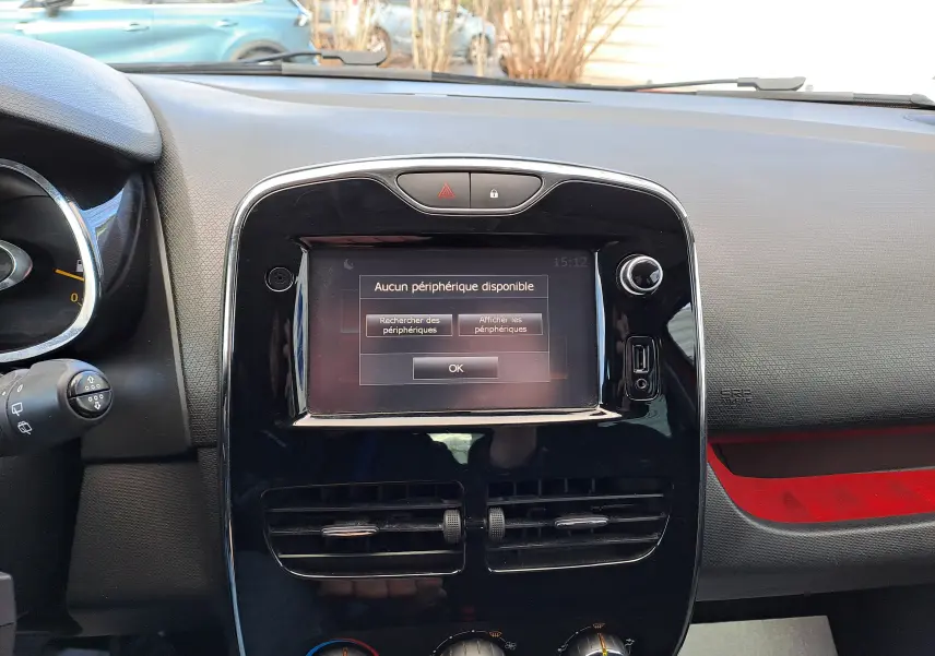 Vue rapprochée du tableau de bord noir de la Renault Clio IV avec écran tactile affichant "Aucun périphérique disponible".
