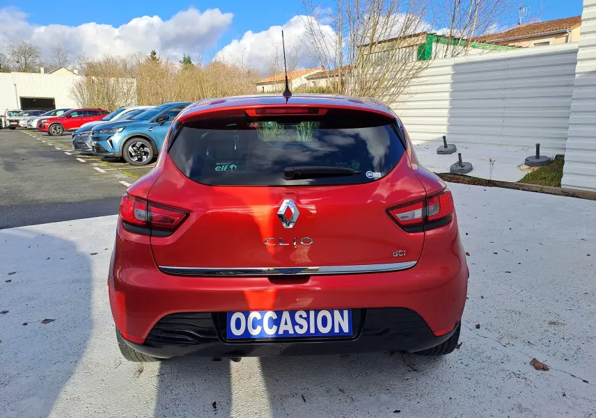 Vue arrière d'une Renault Clio IV rouge 1.5 dCi avec plaque "OCCASION" sur un parking extérieur.