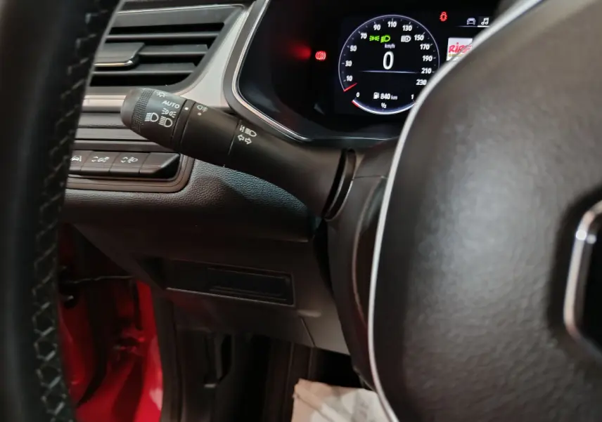 Vue intérieure rapprochée du combiné d'instruments et du commodo gauche du Renault Captur rouge Techno TCe 90 2024.