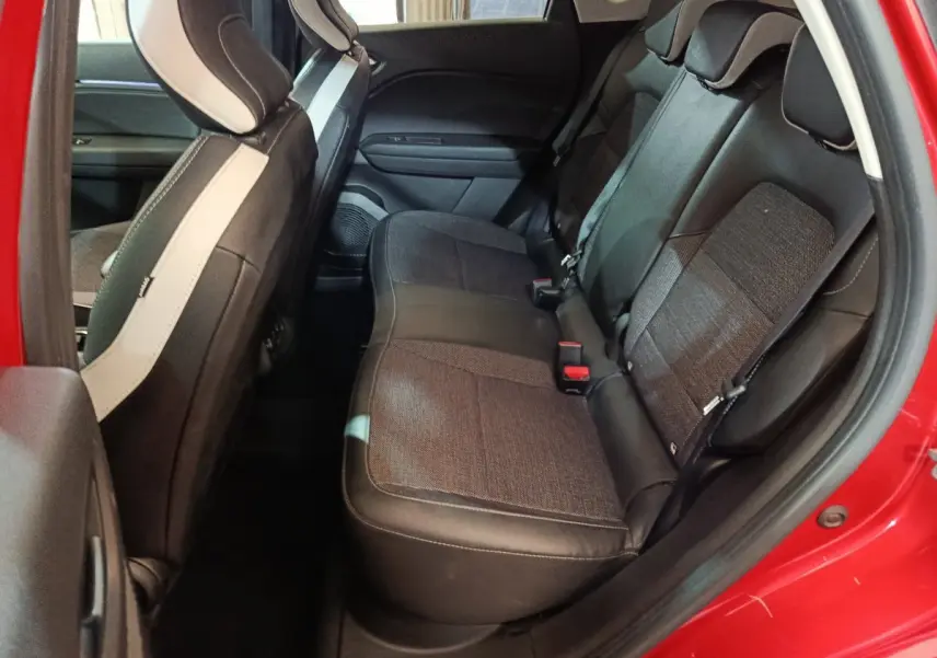 Vue intérieure côté droit sur la banquette arrière noire et grise du Renault Captur rouge 2024, porte ouverte.