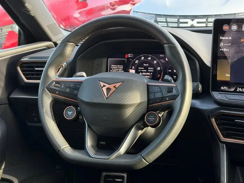 Vue intérieure centrée sur le volant multifonction de la SEAT LEON 1.5 eTSI Hybrid 2025 avec logo Cupra et tableau de bord numérique.