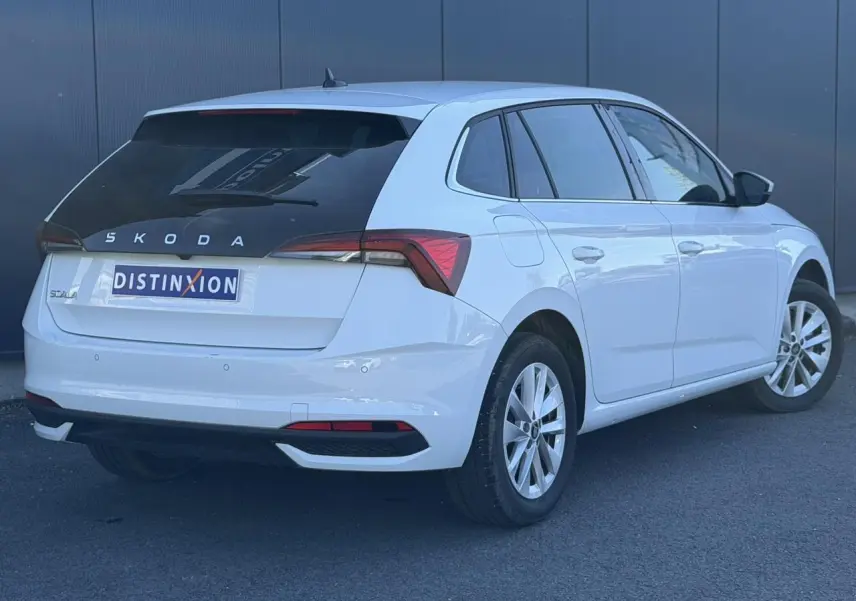 Vue 3/4 arrière droite d'une Skoda Scala blanc glacier avec vitres arrière surteintées et jantes alliage 16 pouces.