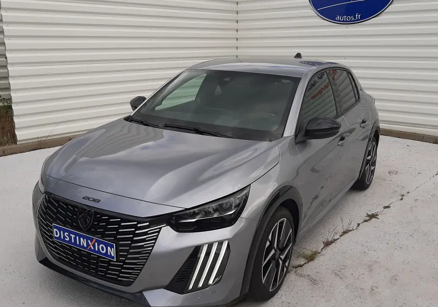 PEUGEOT 208 gris Artense en 3/4 avant droit, avec calandre noire et feux LED verticaux distinctifs.