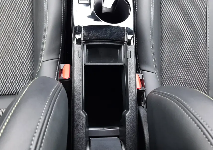 Vue plongeante sur la console centrale noire et les sièges gris anthracite à motifs de la Peugeot 208 1.2 100CH GT 2025.