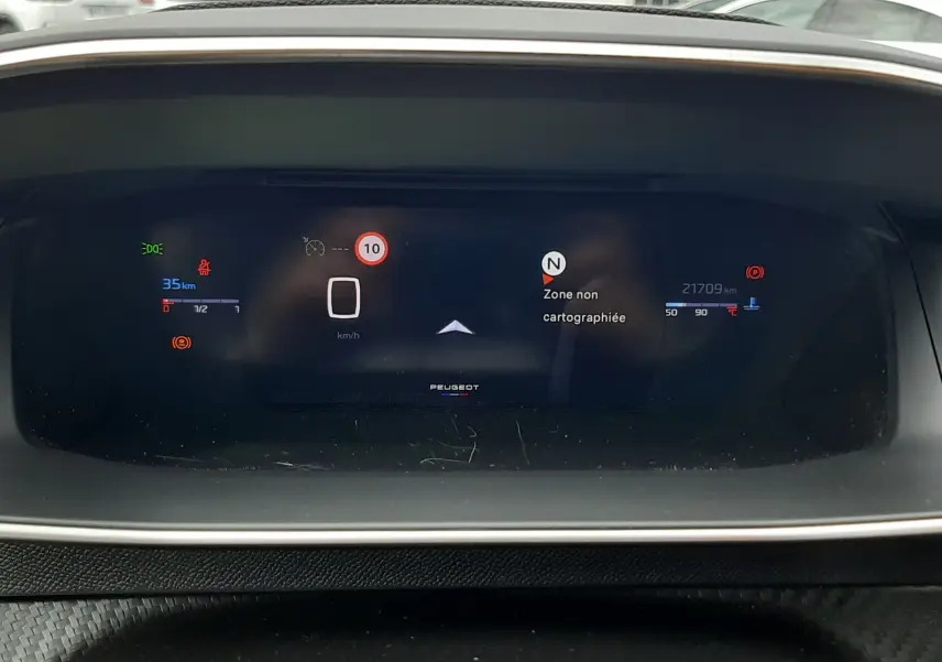 Tableau de bord numérique de la Peugeot 208 1.2 100CH GT, affichant la vitesse et la navigation, intérieur moderne.