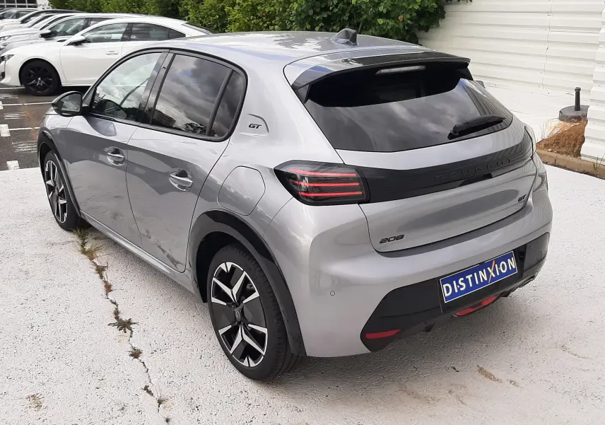 Vue 3/4 arrière droite d'une Peugeot 208 GT gris Artense avec feux LED et jantes alliage noires.