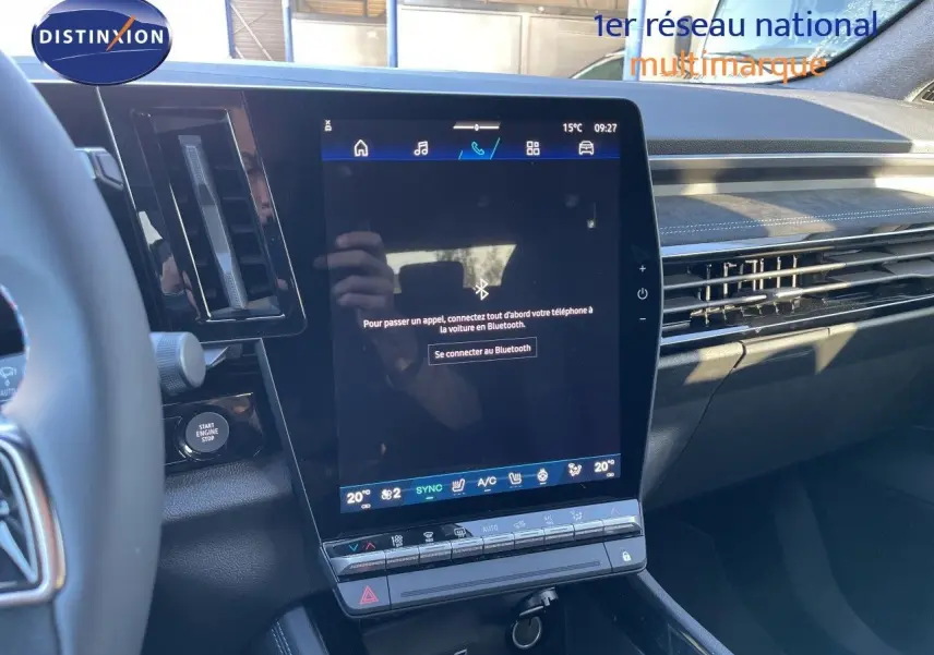 Vue intérieure centrée sur l'écran tactile vertical du tableau de bord du Renault Austral noir étoile métal, avec volant partiel visible.