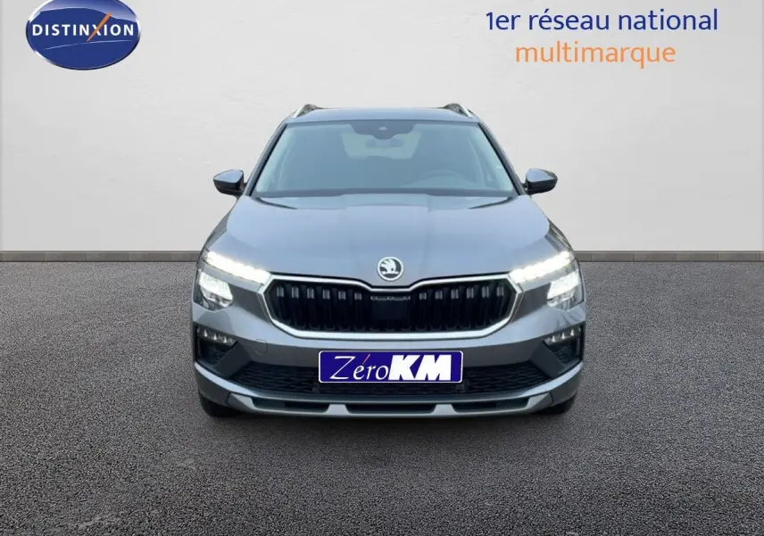 Vue frontale d'un Skoda Kamiq gris graphite métal 2025 avec calandre noire et phares LED allumés.