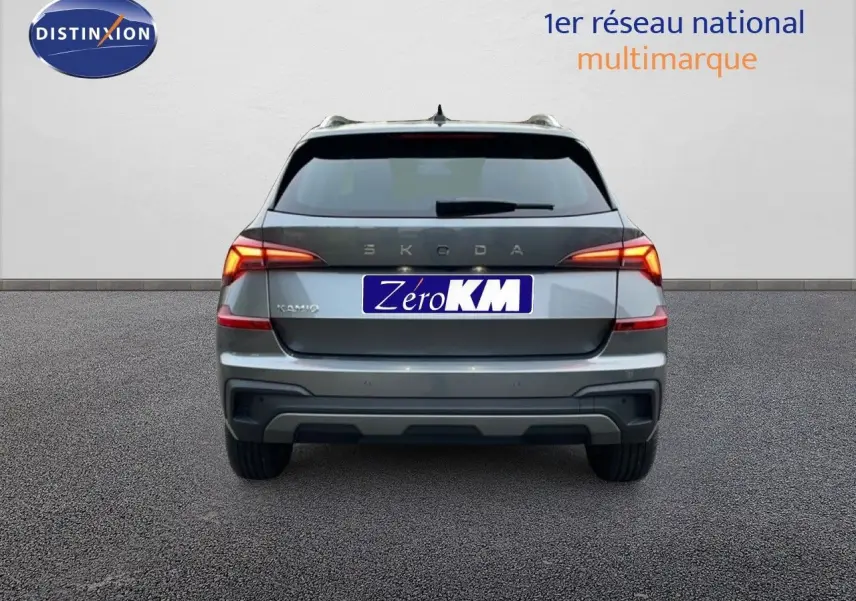 Vue arrière d'un Skoda Kamiq gris graphite métal 2025 avec feux arrière allumés sur fond neutre.