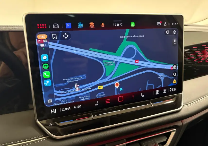 Écran tactile central du Volkswagen Tiguan 2025 affichant la navigation, avec tableau de bord noir et surpiqûres blanches.