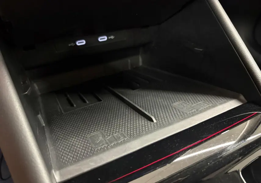 Gros plan sur la zone de recharge sans fil noire avec deux ports USB-C éclairés dans le Volkswagen Tiguan 2025.