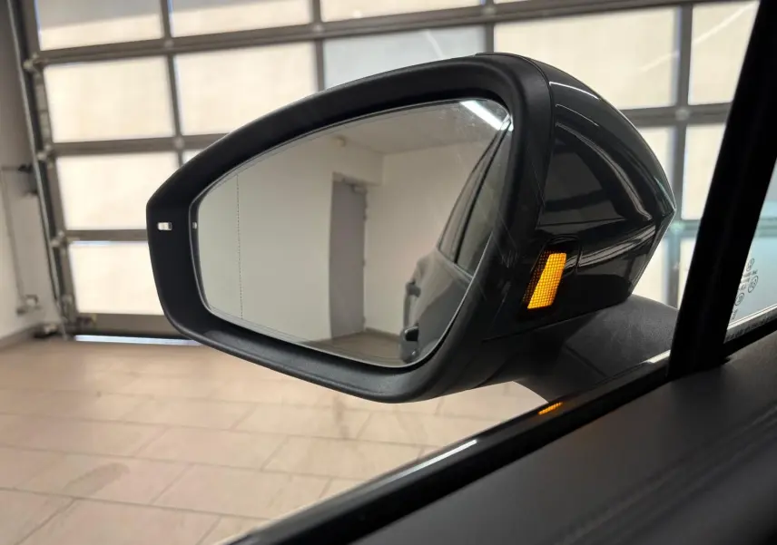 Rétroviseur extérieur droit du Volkswagen Tiguan 2.0 TDI 150 DSG7 Elegance gris Dauphin avec clignotant orange allumé.