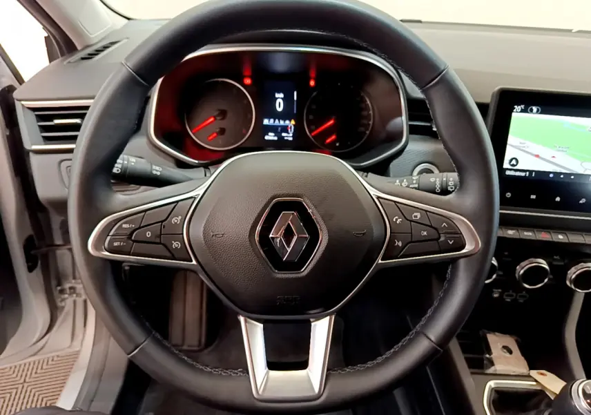 Vue intérieure centrée sur le volant noir de la Renault Clio Business TCe 100 avec tableau de bord et écran tactile visible.