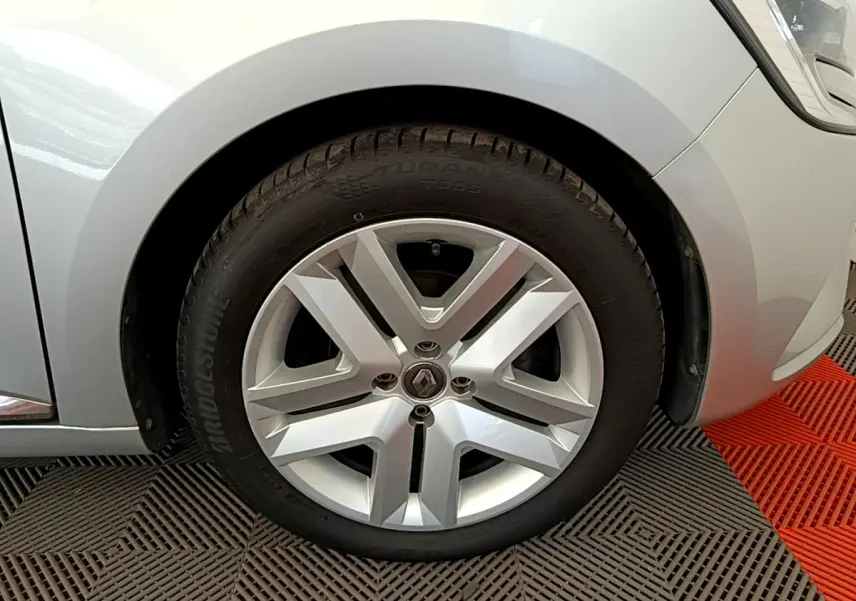 Gros plan sur la roue avant gauche gris clair d'une Renault Clio Business TCe 100 avec jante alliage distinctive.