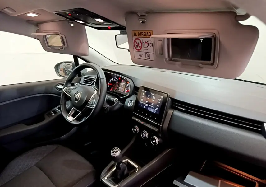 Vue intérieure côté conducteur de la Renault Clio Business 2020, volant cuir, écran tactile 7 pouces et boîte manuelle visible.