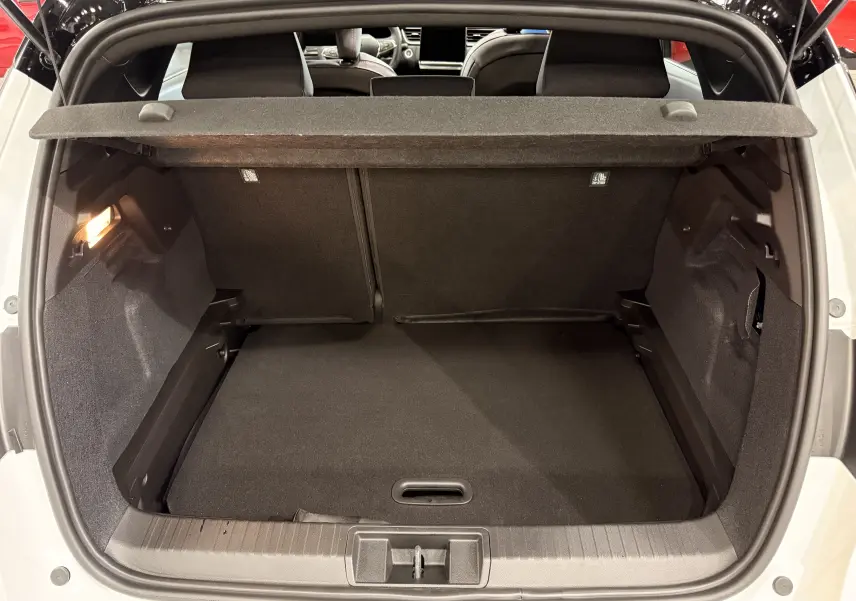 Coffre ouvert vu de l'arrière d'un Renault Captur blanc nacré toit noir, montrant l'espace de chargement vide.