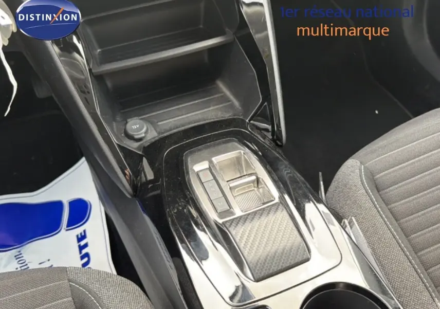 Vue rapprochée de la console centrale noire brillante avec levier de vitesses automatique et siège tissu gris du Peugeot 2008.