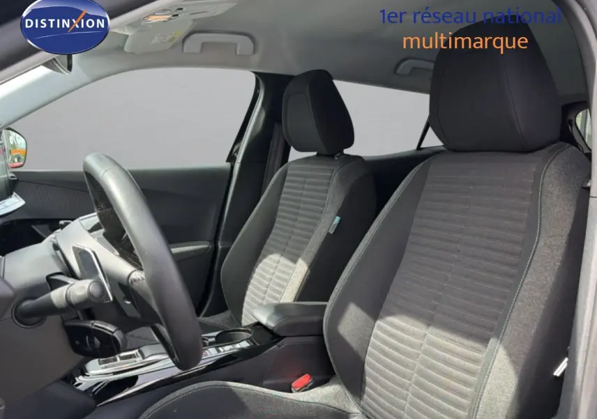 Vue intérieure côté conducteur du Peugeot 2008 2022, sièges tissu noir avec console centrale brillante.