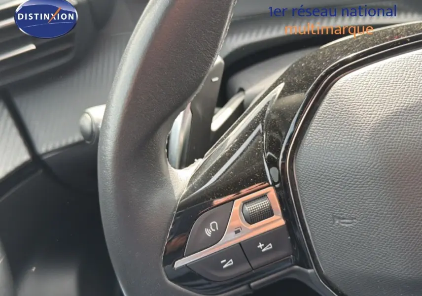 Gros plan sur les commandes gauche du volant noir du Peugeot 2008, soulignant les boutons de volume et de téléphone.
