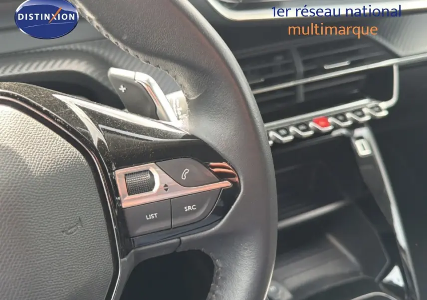 Gros plan sur le volant noir du Peugeot 2008 2022, mettant en valeur les commandes intégrées côté gauche.