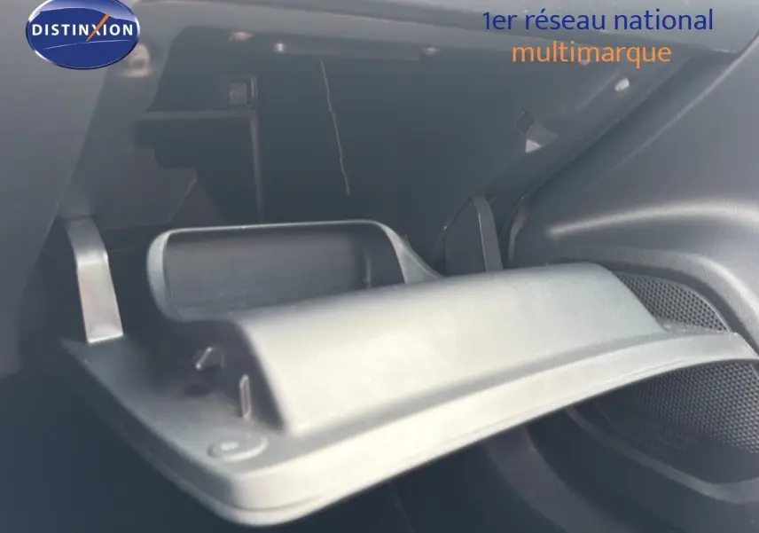 Intérieur du coffre ouvert d’un Peugeot 2008 noir perle métal, vue rapprochée sur le compartiment de rangement.