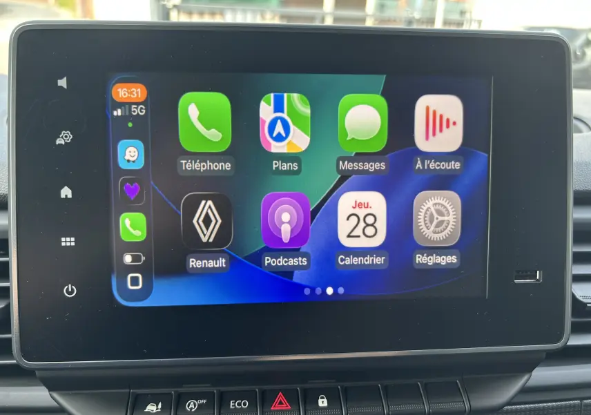Écran tactile central du Renault Trafic L1H1 2025 affichant Apple CarPlay avec icônes colorées, vue frontale rapprochée.