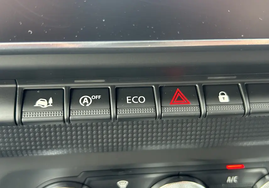 Gros plan sur les boutons de commande du tableau de bord du Renault Trafic Fourgon blanc, avec fonction ECO et alerte triangle rouge.