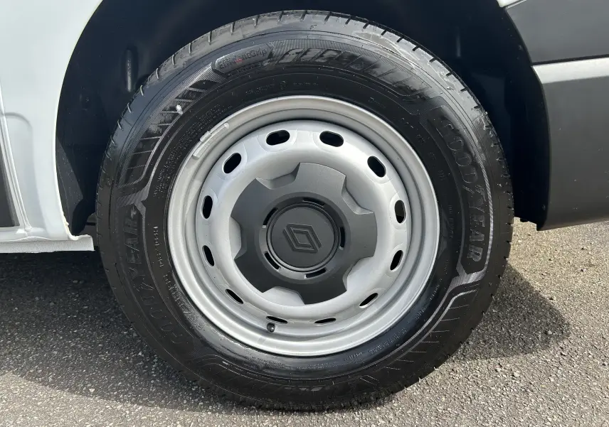 Gros plan sur la roue avant droite du Renault Trafic Fourgon blanc Glacier, jante acier avec logo Renault central.