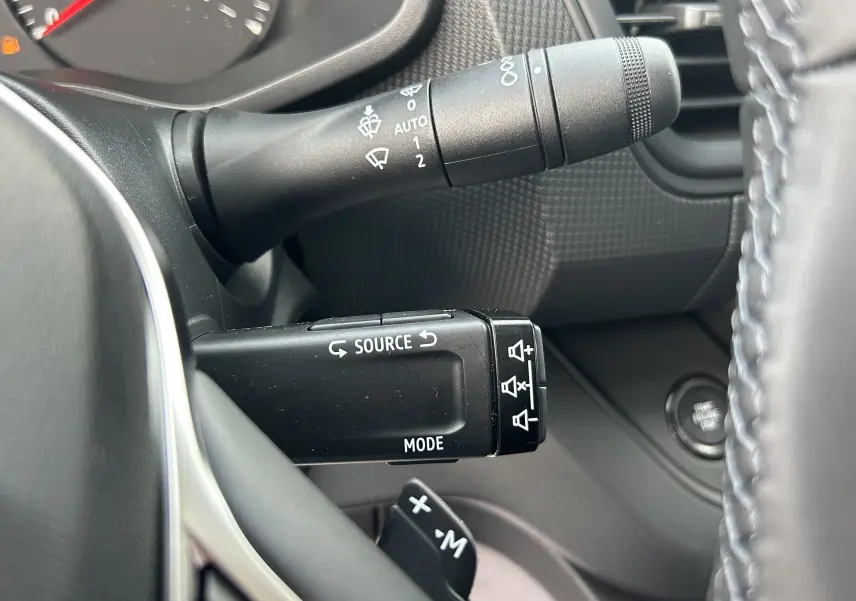 Gros plan sur les commandes au volant du Renault Trafic Fourgon L1H1 2025, avec palettes de changement de vitesse visibles.