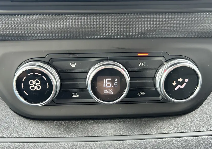Gros plan sur la commande de climatisation automatique du Renault Trafic Fourgon blanc, affichant 16,5°C en mode auto.