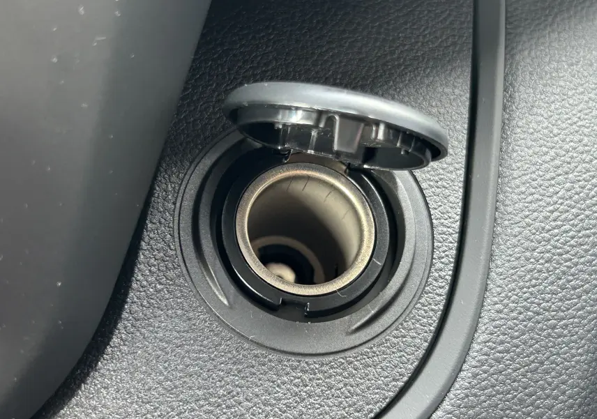 Gros plan sur l'allume-cigare noir intégré dans la console intérieure du Renault Trafic Fourgon blanc Glacier.