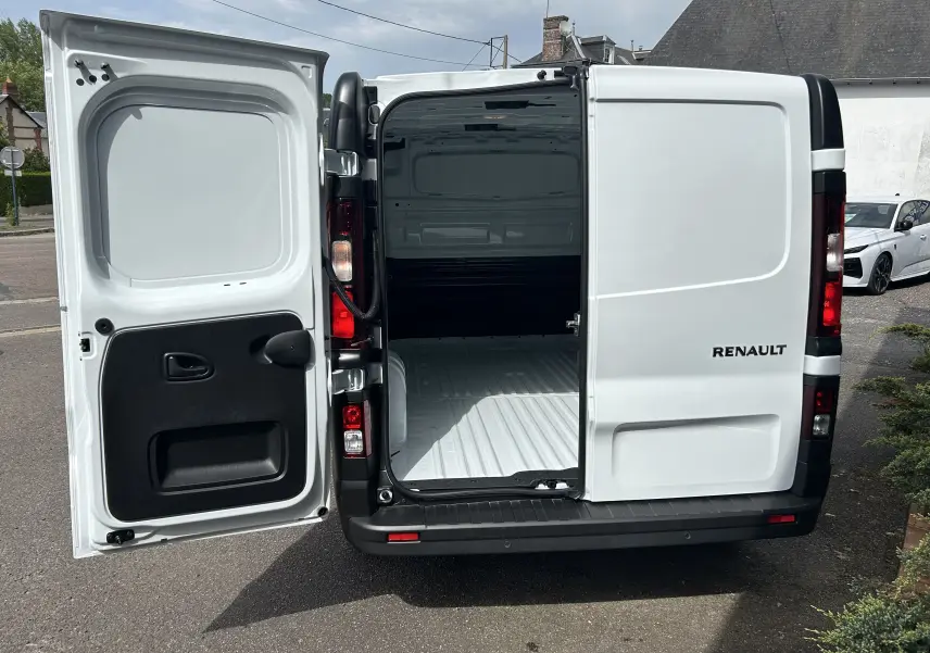 Vue arrière du Renault Trafic Fourgon blanc Glacier avec portes battantes ouvertes montrant l’espace de chargement vide.