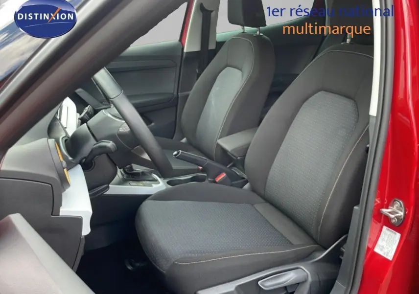 Vue intérieure côté conducteur du SEAT Arona rouge Désir Métal avec sièges tissu gris et volant multifonction.