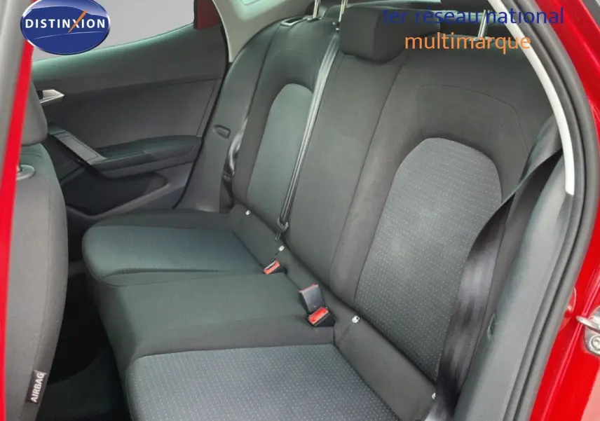 Vue intérieure côté arrière droit montrant les sièges arrière en tissu gris foncé d'une SEAT Arona rouge 2025.