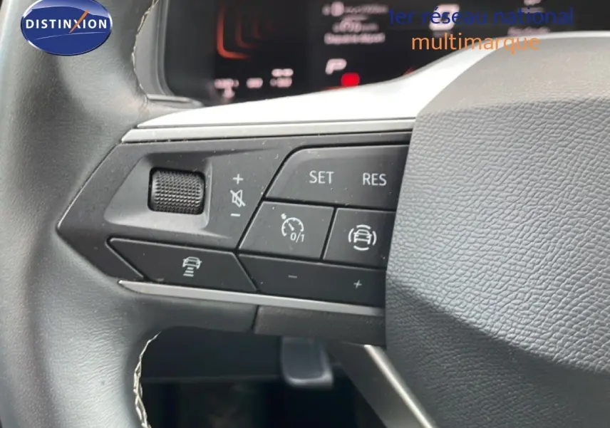 Gros plan sur les commandes au volant du SEAT Arona 2025, mettant en valeur les boutons de régulateur de vitesse et d’assistance.