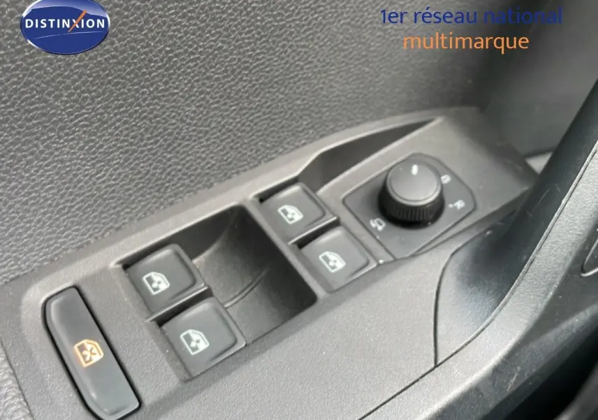Gros plan sur les commandes des vitres électriques et des rétroviseurs côté conducteur d’un SEAT Arona rouge désir métal.
