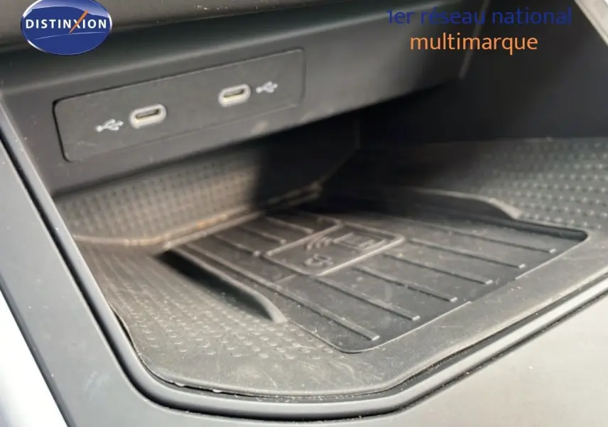 Détail de la console centrale avec ports USB-C et surface de recharge sans fil du SEAT Arona rouge désir métal toit noir.