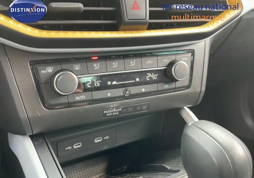 Gros plan sur la console centrale et la commande de climatisation du SEAT Arona rouge désir métal avec toit noir.